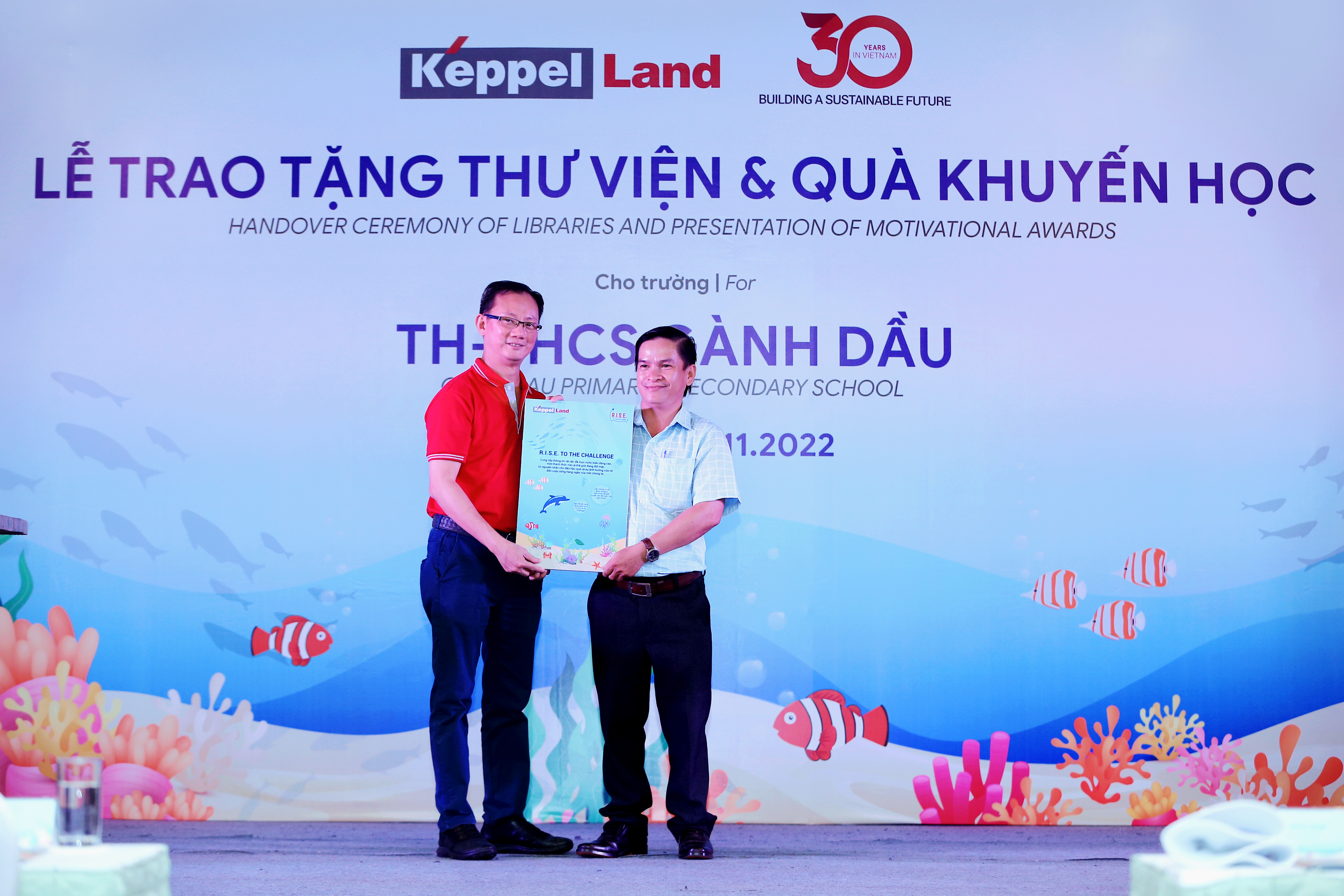 Ông Joseph Low, Chủ tịch Keppel Land Việt Nam trao tặng sách R.I.S.E to the Challenge cho Ông Đào Hữu Tuấn, Phó Hiệu Trưởng trường TH-THCS Gành Dầu.