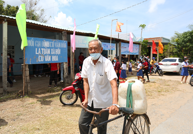 Mr Dang Van Quyt taking clean water home on his bicycle.