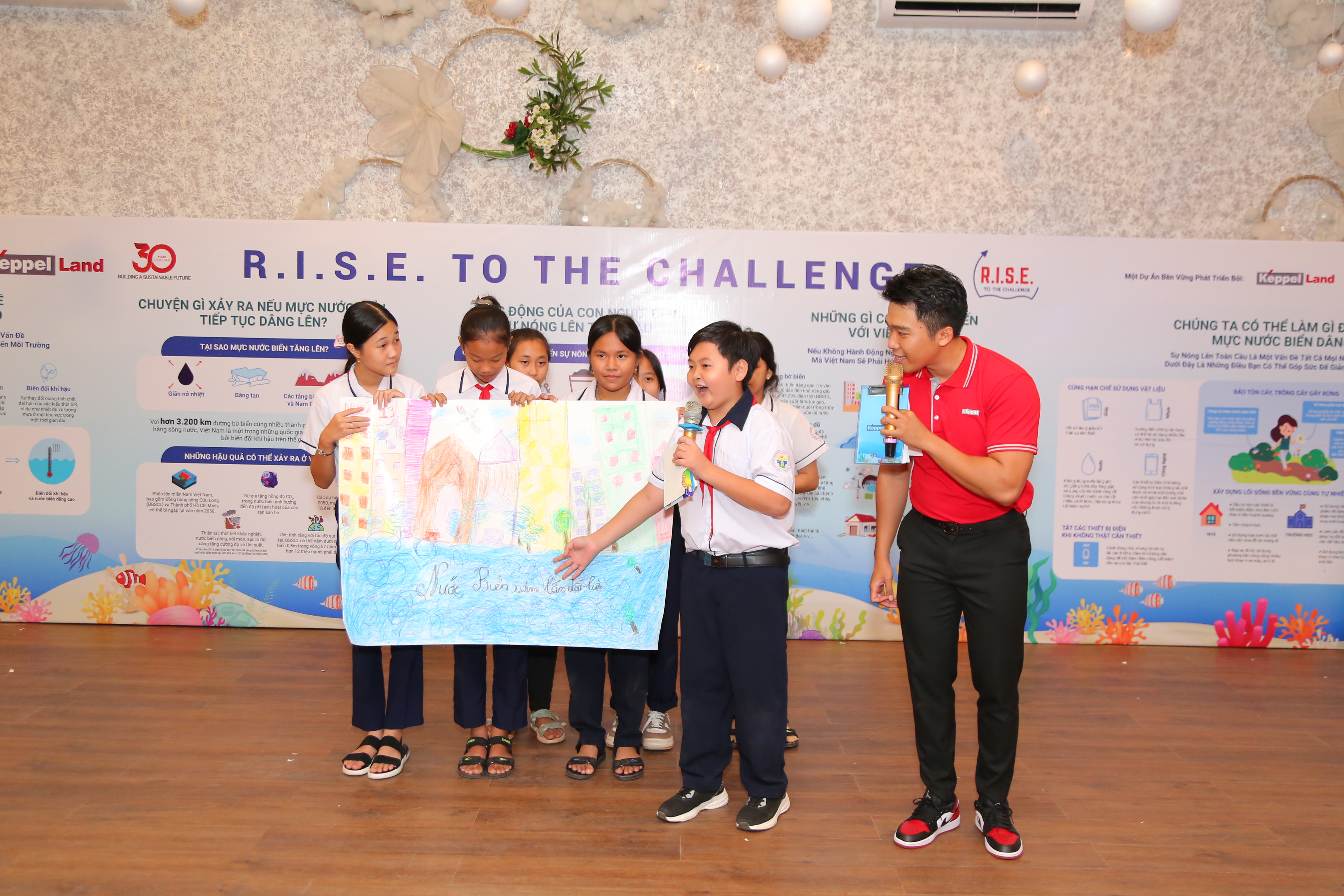 Các em học sinh trường Gành Dầu thuyết trình về bức tranh với chủ đề biến đổi khí hậu tại sự kiện.