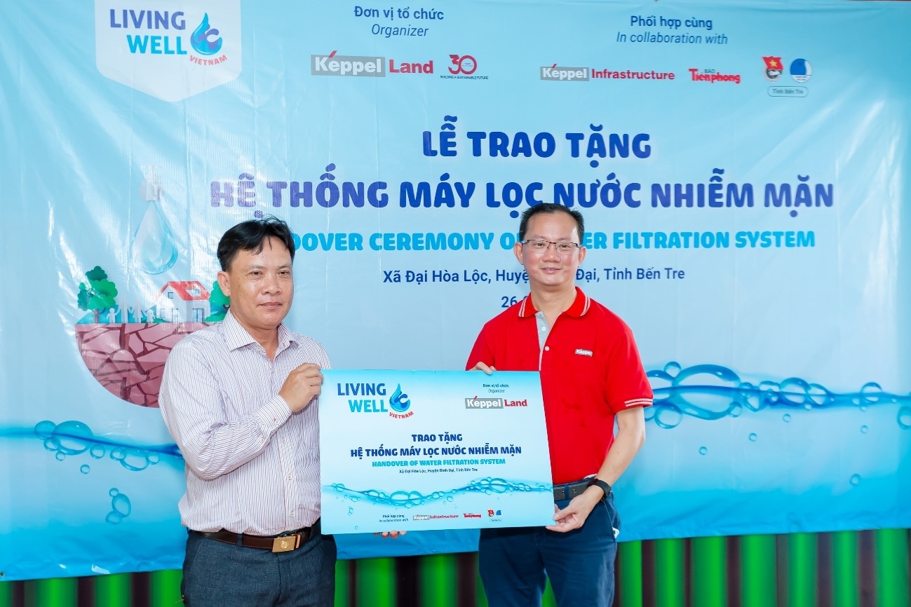 Ông Joseph Low, Chủ tịch Keppel Land Việt Nam (bên phải), trao tặng hệ thống máy lọc nước nhiễm mặn cho Ông Trương Công Lý, Chủ tịch Ủy ban Nhân dân xã Đại Hòa Lộc.